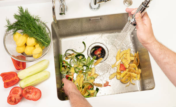 istock A man recycles food waste using a modern kitchen disposer 1396367275