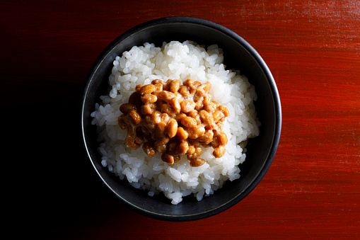 Rice in black bowl isolated on white background