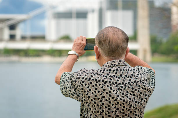 Senior man using smartphone to take photos and video. Travel and technology lifestyle for seniors.
