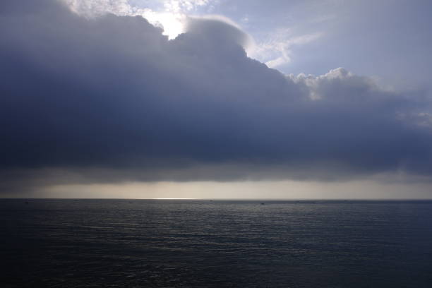 Dramatic stormy dark cloudy sky over sea, natural photo background.
