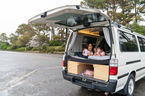 Mother and daughter relaxing in a camper van. Wakayama, Japan