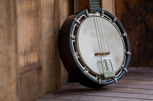 Close-up of a classic Banjo-Mandolin on a slight angle, on decking outside.