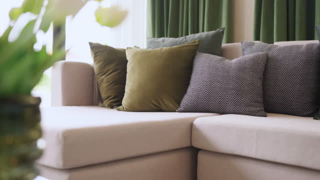 home interior design detail of Modern clean living room with soft and cozy sunlight pillow upholsty curshion arrange on white sofa dolly shot close up,home sweet home background