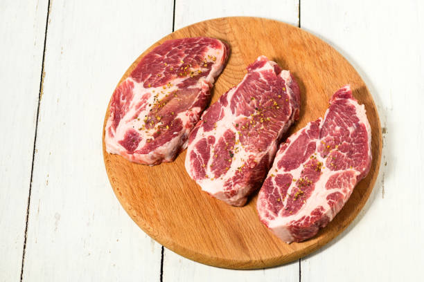 viande de porc crue tranchée avec des épices sur une surface en bois, vue de dessus - filet mignon bacon fillet steak photos et images de collection