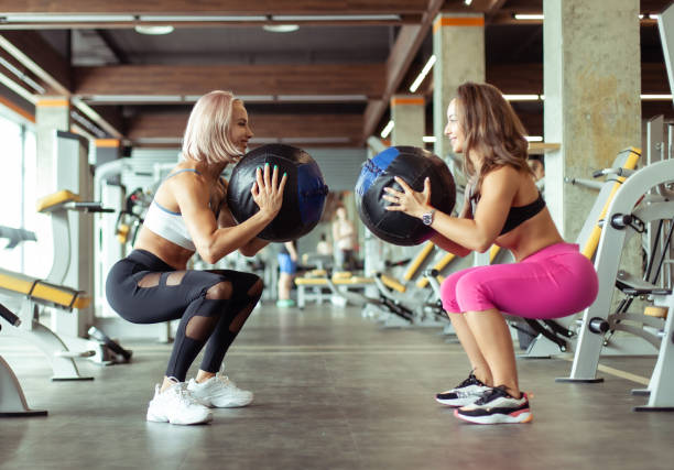 istock Two athletic women exercise with medicine balls in the gym. Functional training 1396397957
