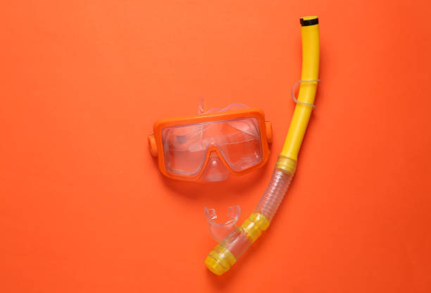 istock Diving mask with snorkel on orange background. Top view 1396401391