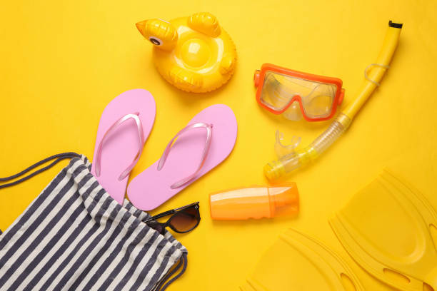 istock Beach bag with beach accessories on a yellow background. Top view. Flat lay 1396401418
