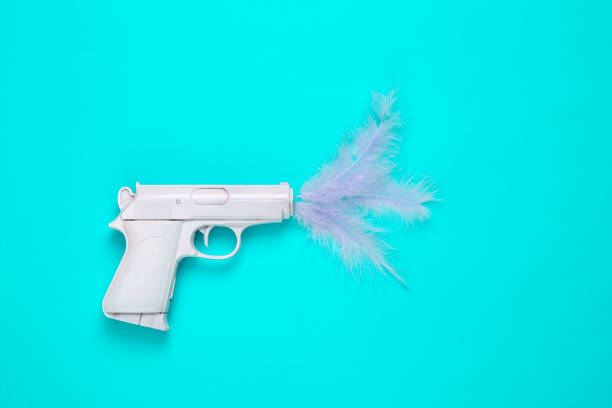 istock Minimal layout. White gun with feathers on a turquoise background. 1396401445