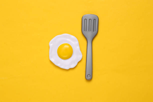 istock Plastic scrambled eggs and fork on yellow background. Top view. Minimal food concept 1396401461