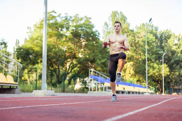 istock Athletic man with a naked torso practicing jumping up, warming up before running to the stadium. Healthy lifestyle 1396402395
