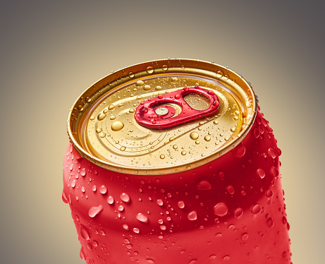 Wet surface of a red metal can with a cold drink close-up