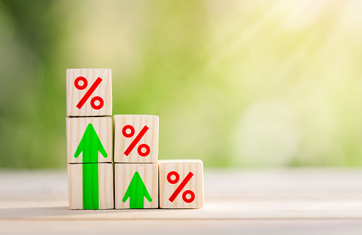 Interest rate financial and mortgage rates concept. Wooden blocks are lined up in steps with up arrow and interest symbols. Mortgage rates business concept of investment,  interest rates appraisal.