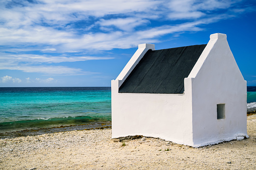 A view of the slave houses on Bonaire in the Caribbean with a blue sky and turquoise sea