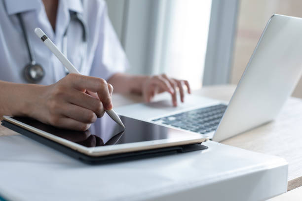 istock Doctor working on digital tablet and laptop computer in office 1396411053