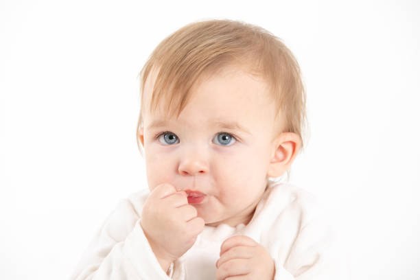 istock Baby's face with the hand in the mouth 1396413141