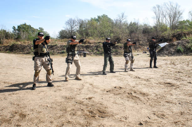 Group of army soldiers practice gun shooting on target Group of army soldiers practice gun shooting on target on outdoor shooting range. Firearm shooting and tactical training officer military rank stock pictures, royalty-free photos & images
