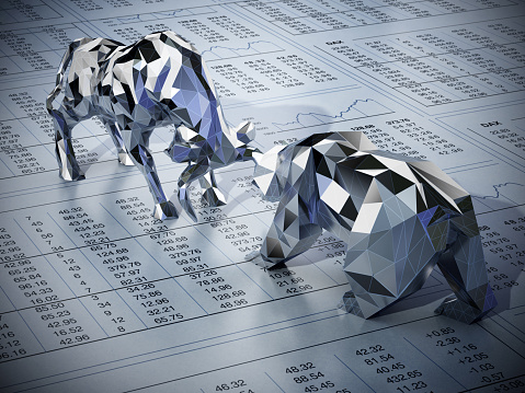 Stylized low poly bull and bear standing and facing each other on newspaper page with financial data. Business and finance concept.