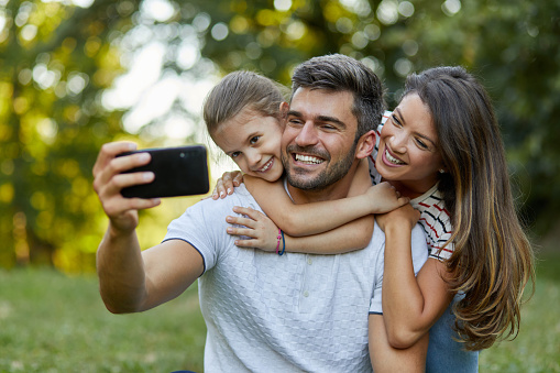 Happy family taking selfie in the park