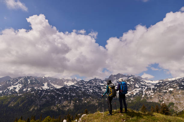 istock Hikers with backpacks relaxing and enjoying the view 1396419655