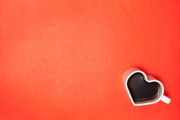 istock Heart shape coffee cups over red background. View from above. 1396421213