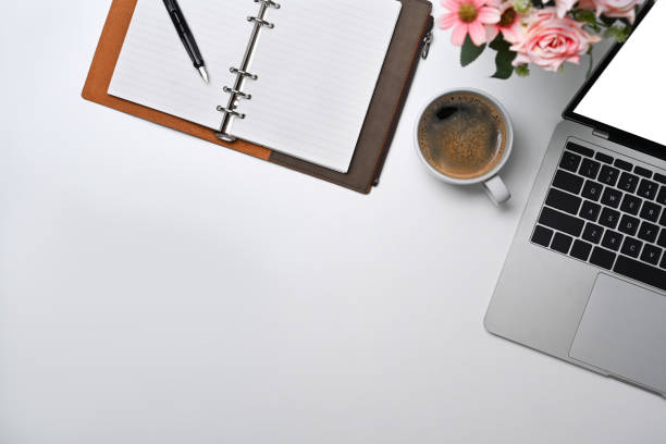 istock Top view white office desk with laptop, notebook and coffee cup. 1396421243