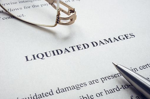 Documents about Liquidated damages with pen.