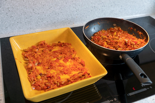 Preparing vegetarian enchiladas in a modern kitchen.