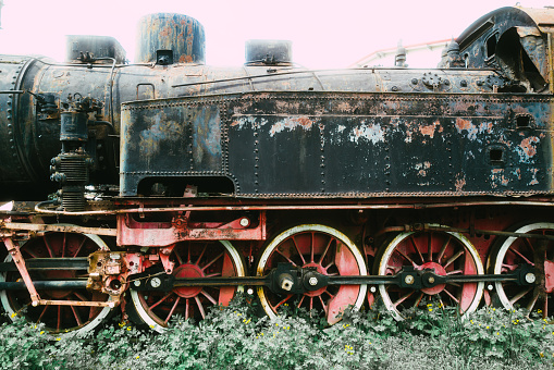 Old rusty steam locomotives left to ruin and decay at the train yard.