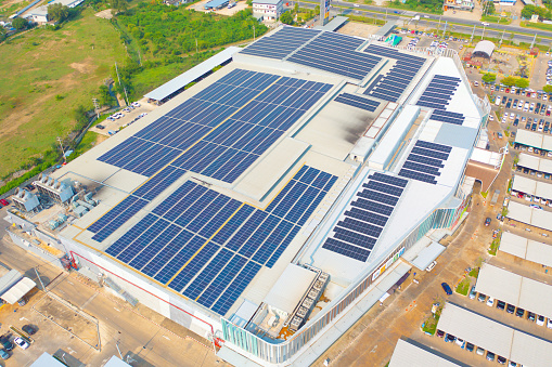 Aerial view of solar panels or solar cells on the roof of shopping mall building rooftop. Power plant, renewable clean energy source. Eco technology for electric power in industry.