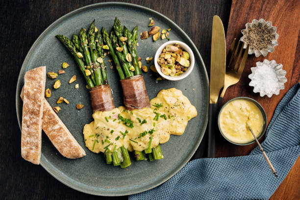 asparagus wrapped with parma ham, hollandaise sauce and pistachios - hollandaise sauce imagens e fotografias de stock