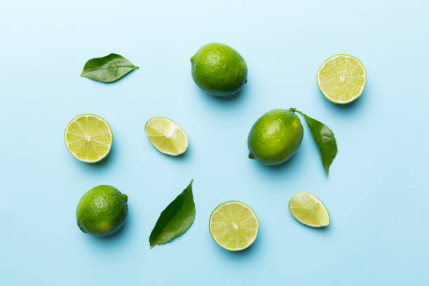istock Lime fruits with green leaf and cut in half slice isolated on white background. Top view. Flat lay with copy space 1396427670