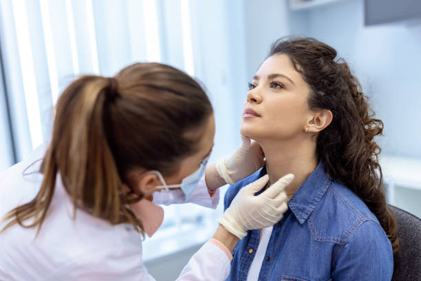 medizin, gesundheitswesen und medizinisches untersuchungskonzept - arzt oder krankenschwester überprüfen die mandeln des patienten im krankenhaus. endokrinologe untersucht hals einer jungen frau in der klinik - thyroid gland stock-fotos und bilder