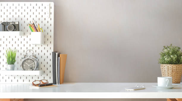 istock Comfortable workplace with supplies, coffee cup and houseplant on white table. 1396431371