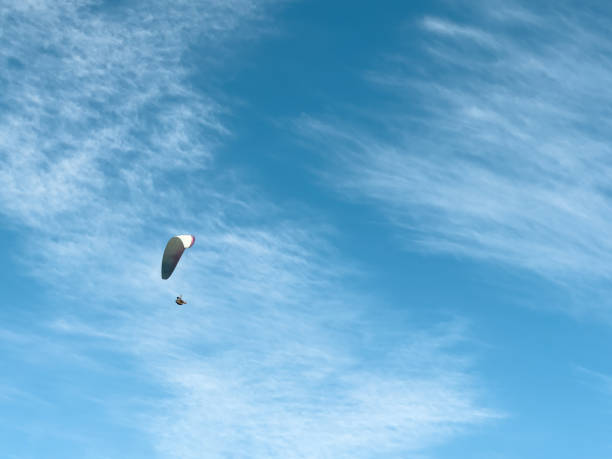 istock Flying paraglider on a background of bright blue sky with soft clouds 1396433461