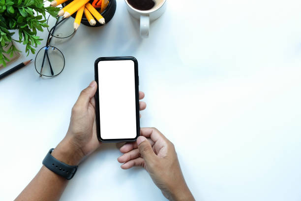 istock Overhead view businessman sitting at office desk and using smart phone. 1396433566