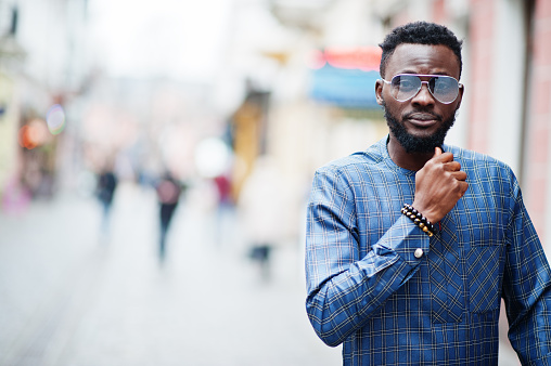 African guy in blue authentic costume, eyeglasses. Fashionable nigerian man.
