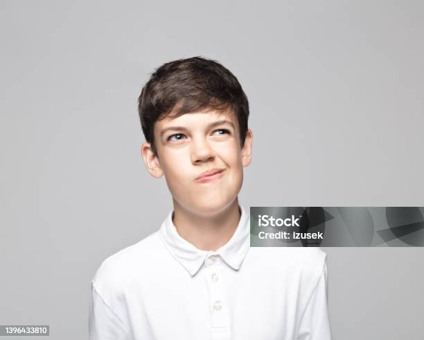 Confused Teenage Boy Against Gray Background Stock Photo - Download Image Now - Adolescence, Confusion, Contemplation
