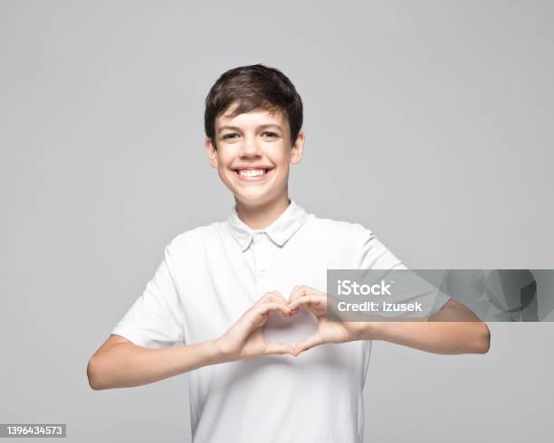Happy Teenage Boy Gesturing Heart Shape Stock Photo - Download Image Now - Heart Shape, Teenage Boys, Portrait