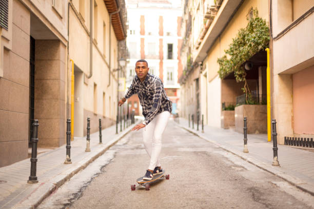 istock young african american man rollerblading with long board on the street 1396435108