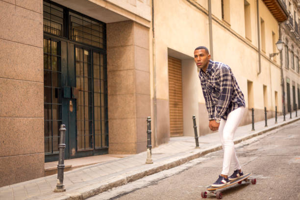 istock young black man rollerblading with long board on the street. 1396435111
