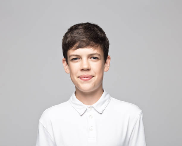 istock Smiling teenage boy over gray background 1396435284