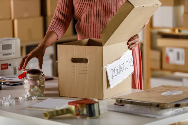 istock Woman putting a jar of candy in a donations box 1396436005
