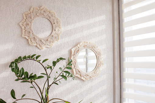 Macrame mirror and wreath on a white wall.  Eco-style. Natural materials.