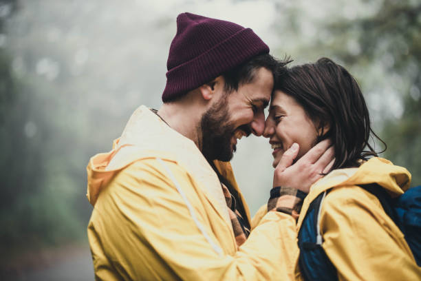 istock Happy affectionate couple in raincoats enjoying in nature. 1396438036