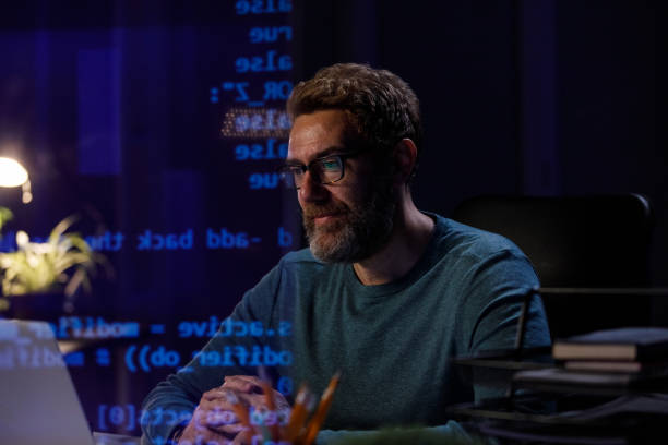 istock Serious mature working late at his desk, reviewing data on laptop 1396438124