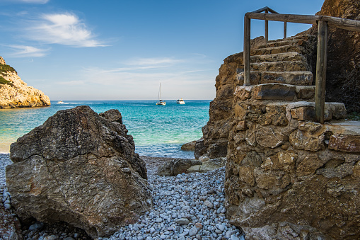 The rock and the stairs to the turquoise sea, Cala Granadella, Alicante.