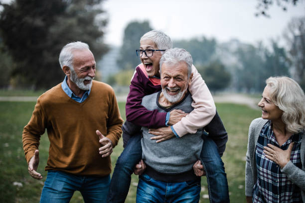 istock Playful mature couples having fun during autumn day in nature. 1396439026
