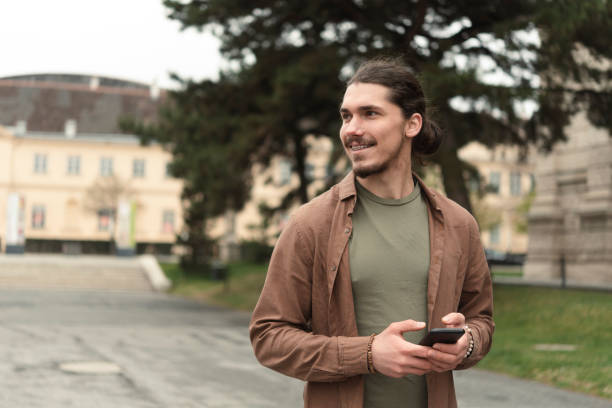 istock Portrait of a young man using smartphone on the move 1396439219