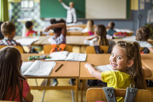 istock Happy schoolgirl attending a class in the classroom. 1396439403