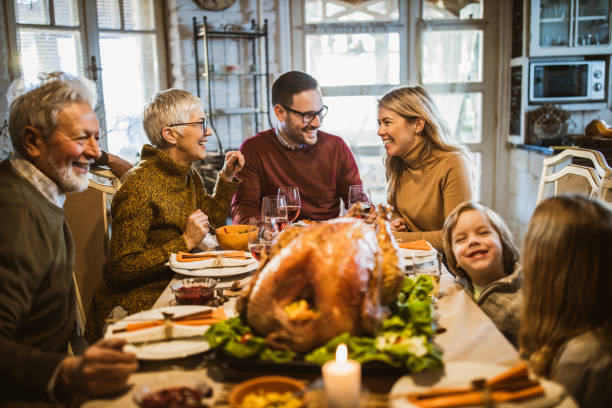 istock Happy extended family talking during Thanksgiving meal at dining table. 1396440419